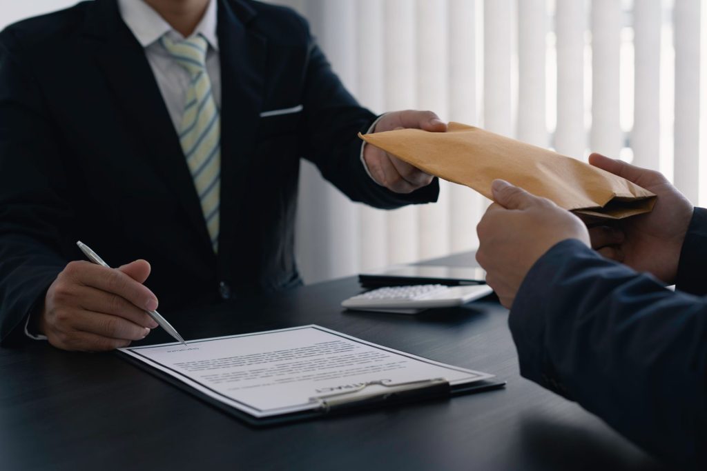 2 professionals at work exchanging documents